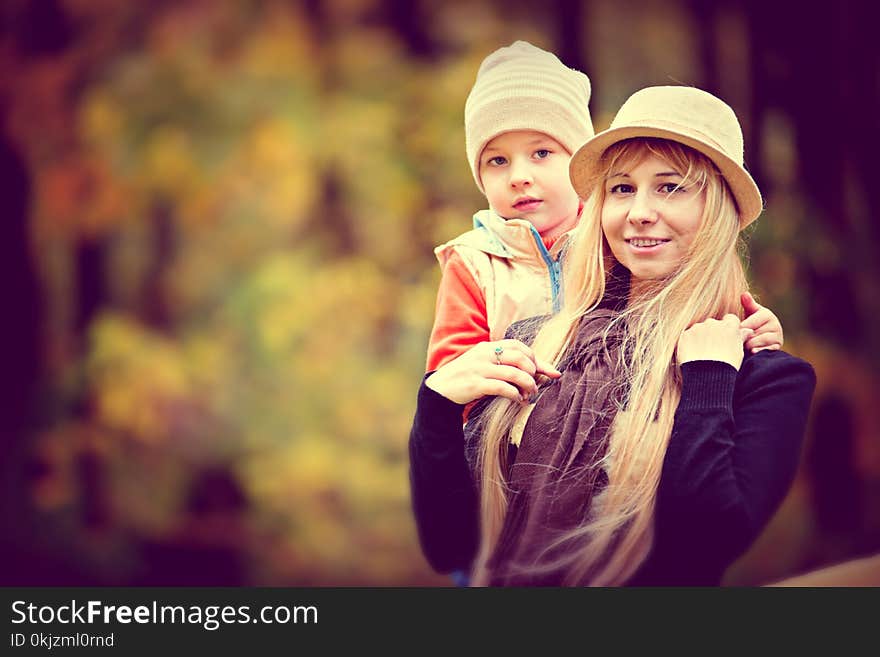 Shallow Focus Photo of a Woman Carrying a Toddler