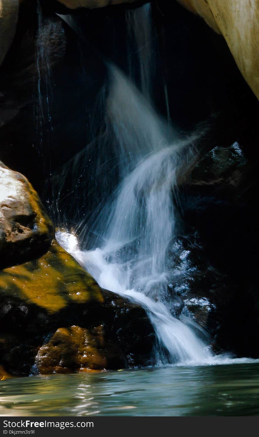 Photo of Running Water Between Brown Rocks