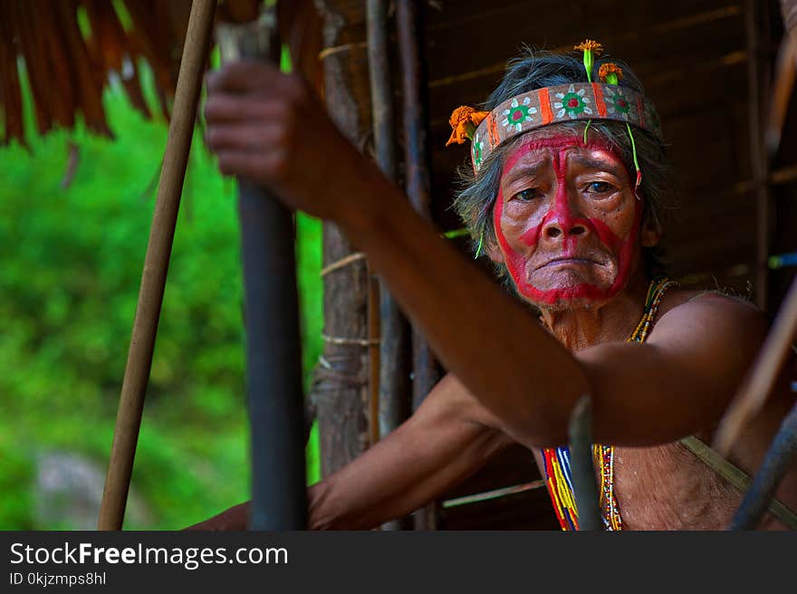 Selective Focus Photography of Man Holding Stick Wearing Headband