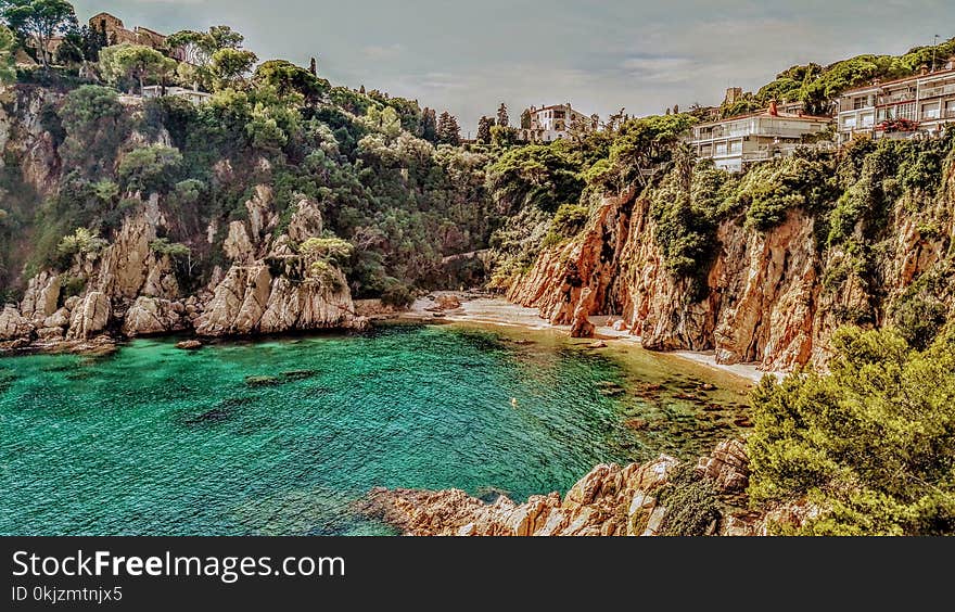 Photo of Body of Water Surrounded by Cliff