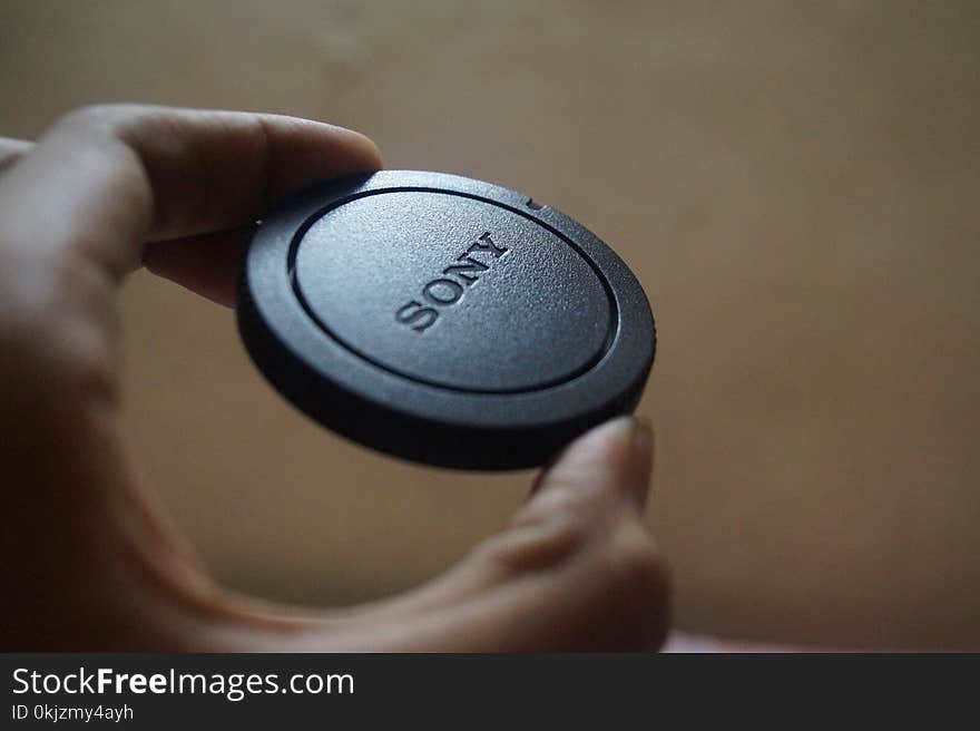 Person Holding Sony Camera Lens Cover