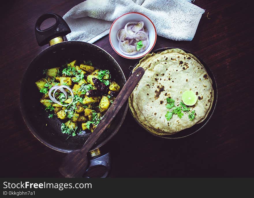 Baked Roti Topped With Sliced Lime Beside Onion Ring in White Bowl