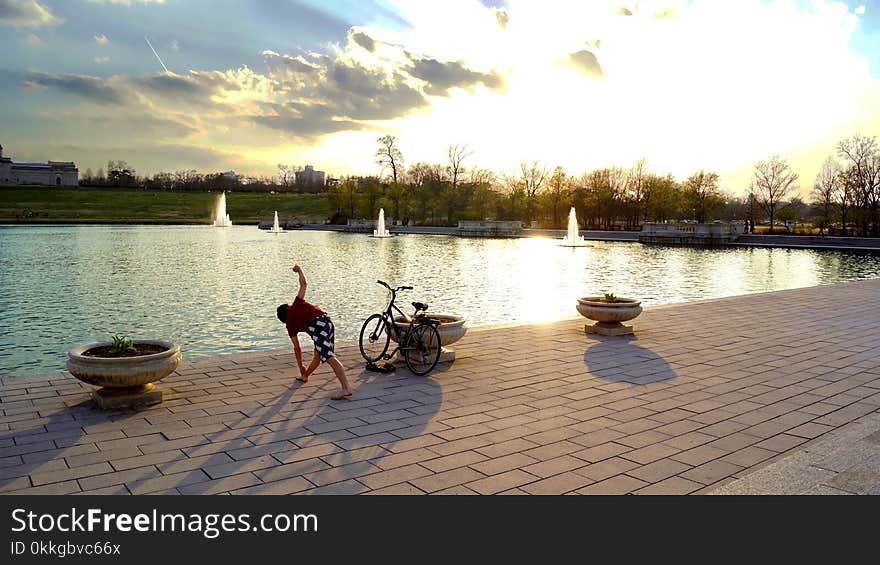 Man Standing Near Bicycle and Body Water