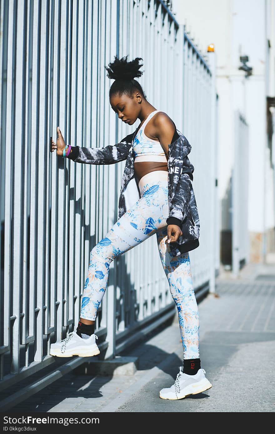 Woman Wearing White and Blue Pants and Pair of Gray-and-white Low-top Sneakers