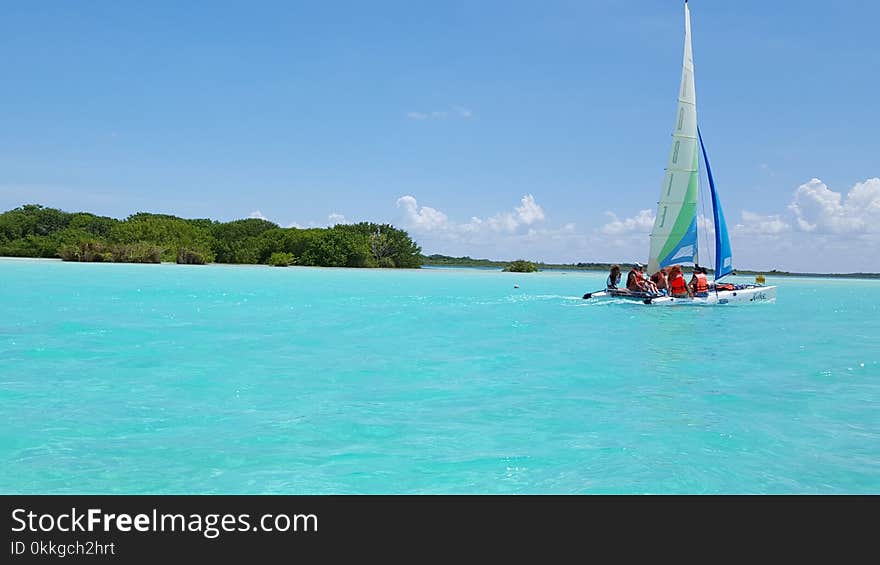 Group of People Riding Sailboat on Body of Water