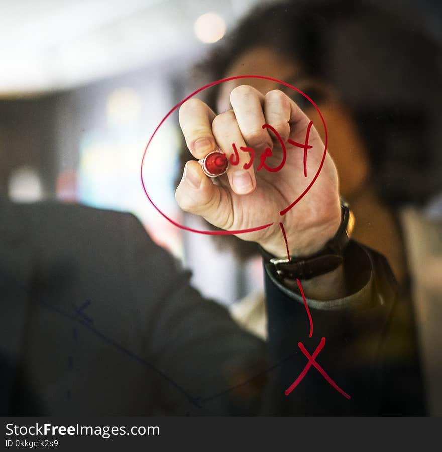 Person Wearing Black Watch Writing on Mirror Using Red Pen