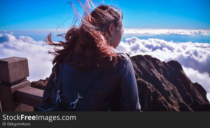 Woman Standing Near Cliff Above Clouds