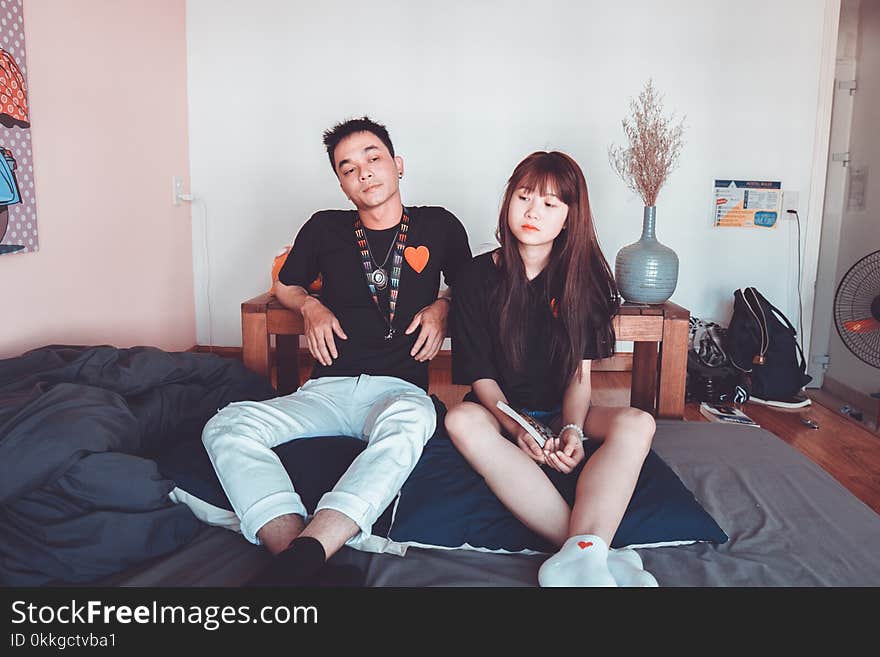 Photo of Woman and Man Sitting Beside Each Other on Mattress