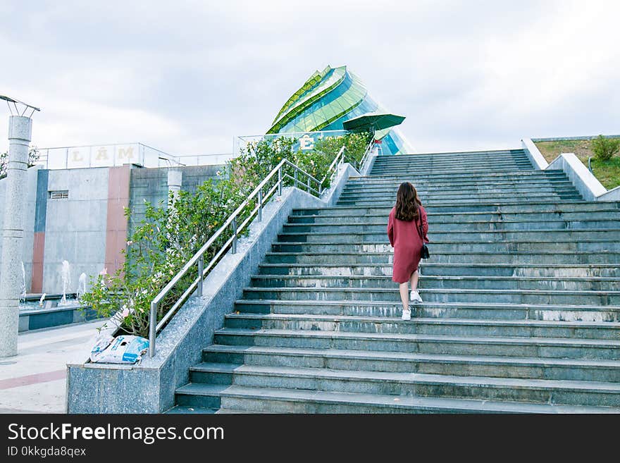 Woman Wearing Red Dress on Gray Stairs