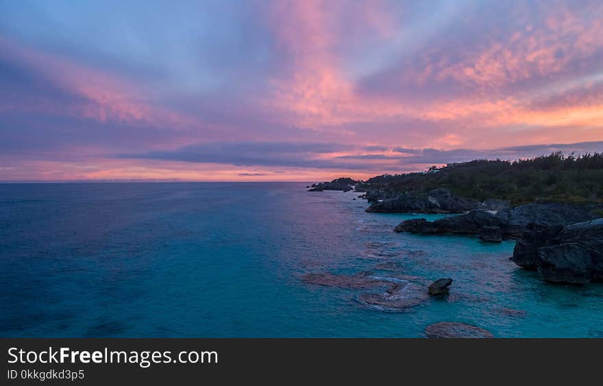 Green Trees Near Body of Water Under Blue and Orange Sky during Golden Hour