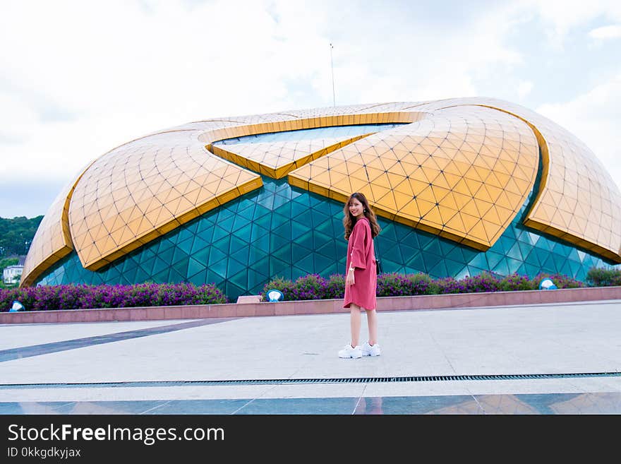 Woman Standing in Front of Yellow and Blue Glass Building