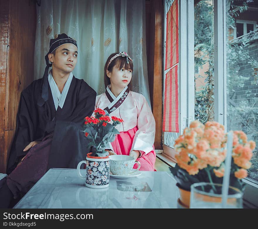 Couple Wearing Korean Traditional Dress Near Windowpane Staring at the Window