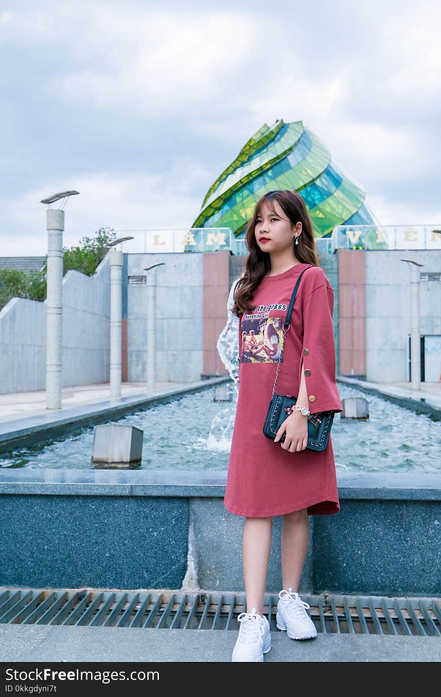 Woman Wearing Red Dress Standing Near Fountain