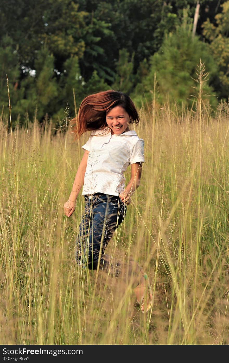 Woman Jumping Between Grass