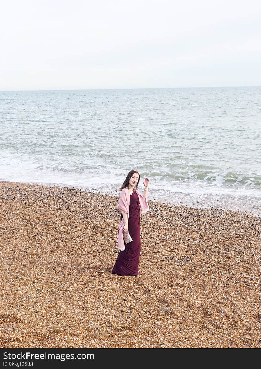 Woman Wearing Maroon Long Dress Near Seashore