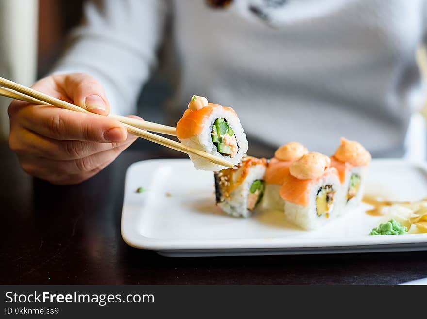 Close up of young beautiful woman holding chopsticks in Japanese restaurant. Close up of young beautiful woman holding chopsticks in Japanese restaurant