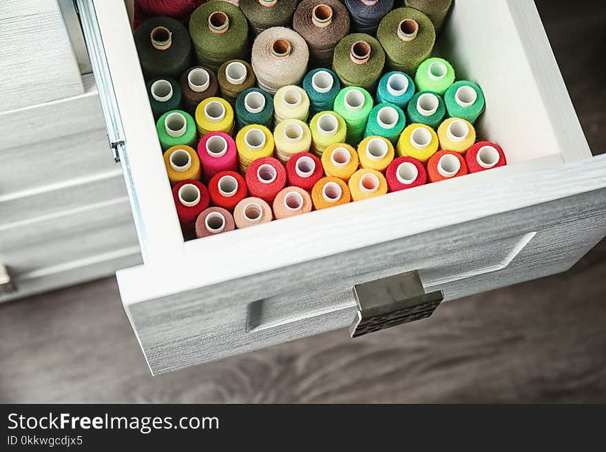 Colorful sewing threads in open drawer