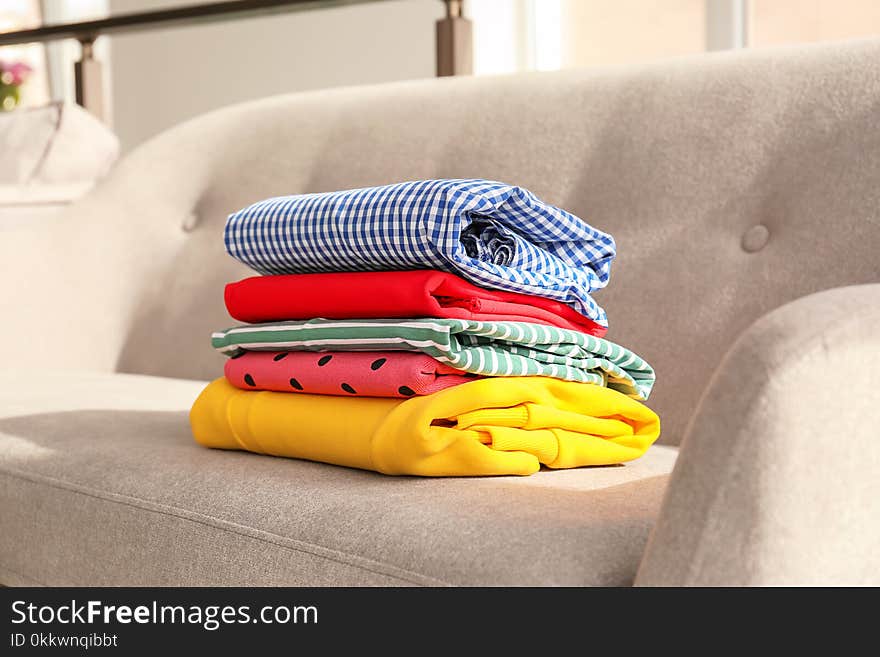 Stack of clothes on sofa in living room