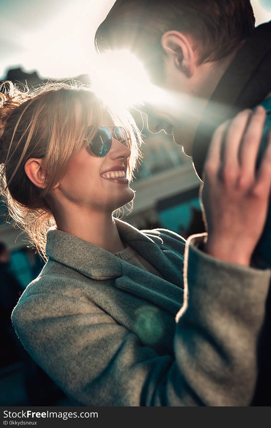 Happy playful couple in sunglasses in love dating joking and laughing in the street. Happy playful couple in sunglasses in love dating joking and laughing in the street