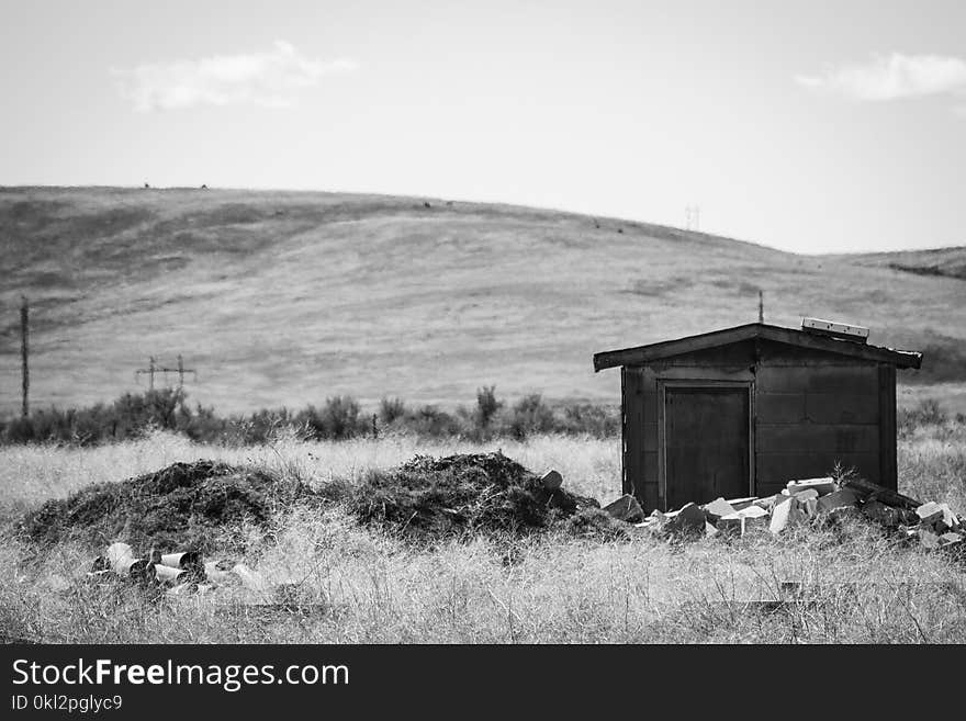 Greyscale Photography of Brown Shed Near Mountain