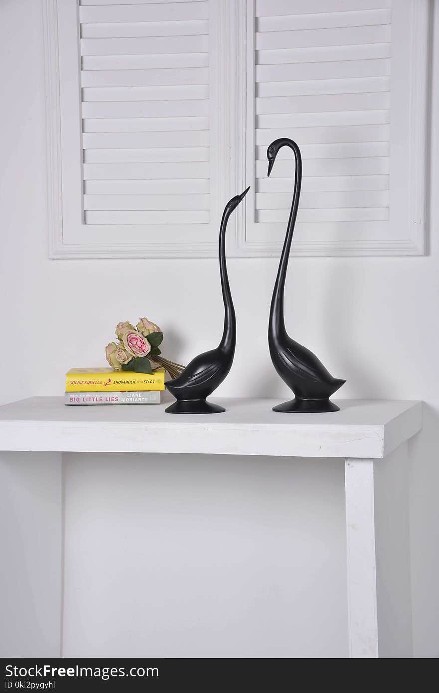 Two Black Geese Figurines on White Console Table