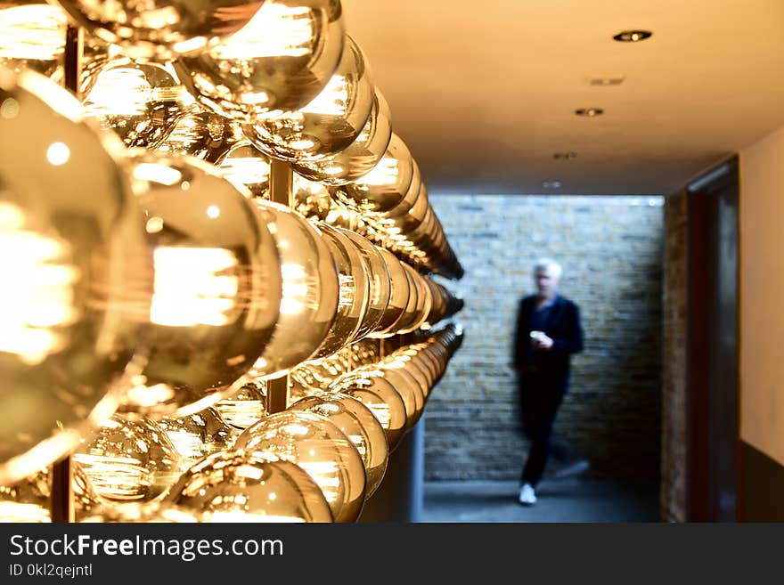 Man Passing Near Brown Brick Wall