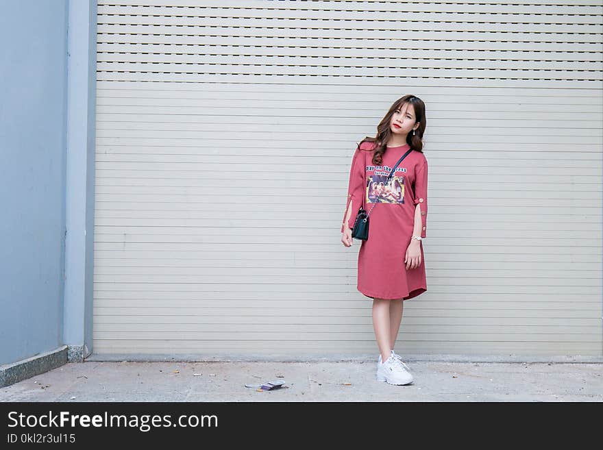 Standing Woman Wearing Red Dress Beside Roll Top Door