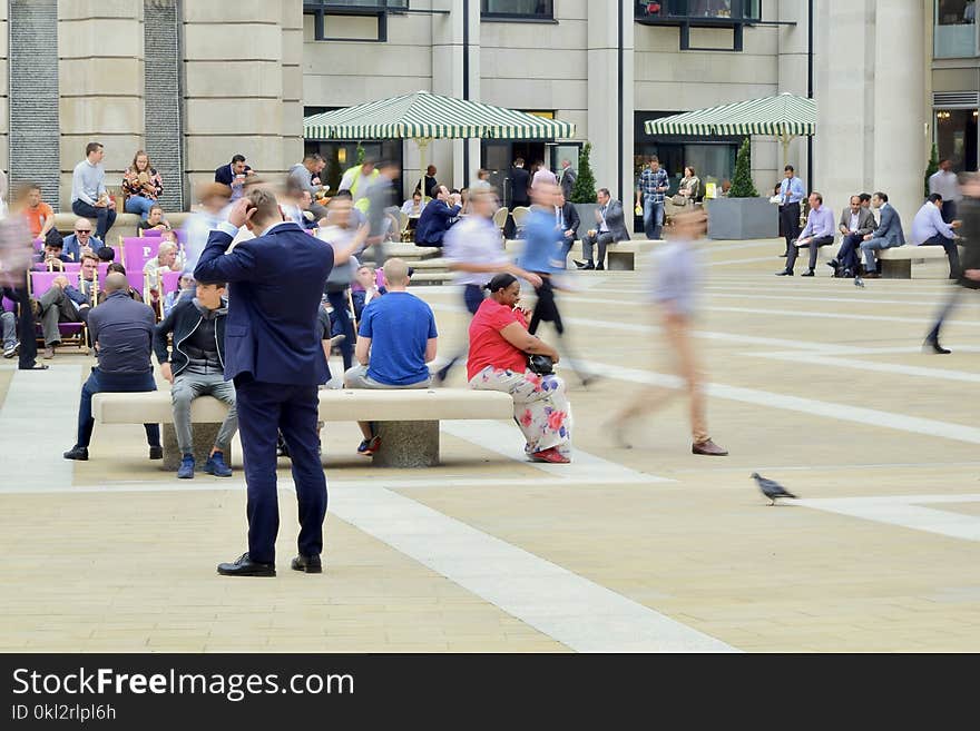 Man Wearing Blue Suit on Beige Ground Near Building