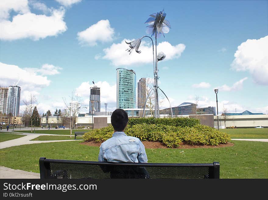 Man Wearing Blue Top Sitting on Black Bench