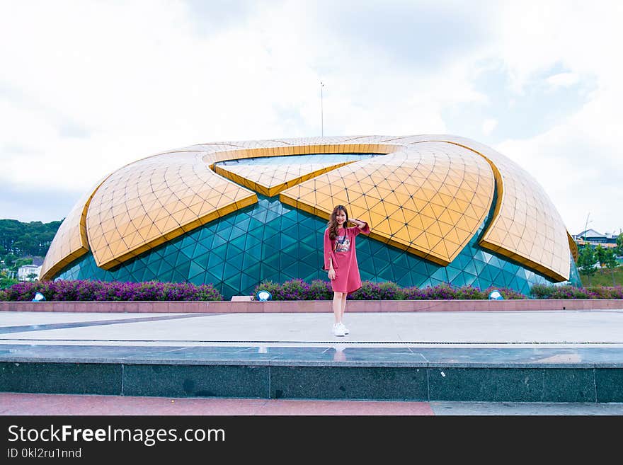 Woman in Red Dress Standing Near Stadium