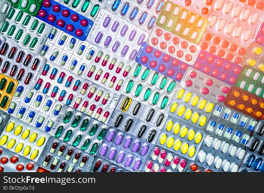 Colorful of tablets and capsules pill in blister packaging arranged with beautiful pattern with flare light. Pharmaceutical