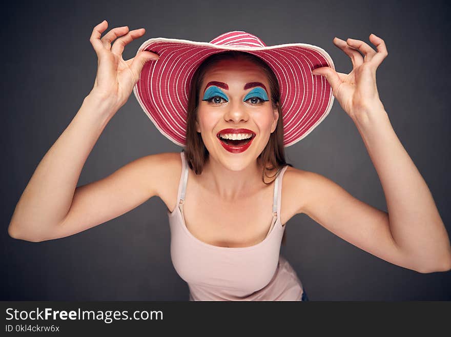 Crazy beauty fashion portrait of woman wearing red summer hat.