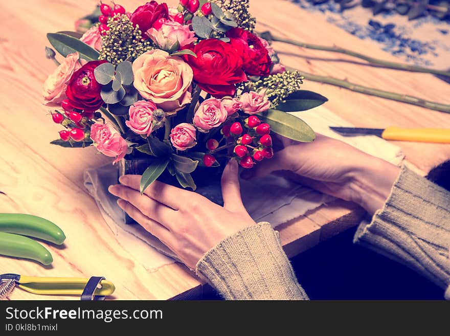 Florist at work assembling the bouquet of tulips in a hat box