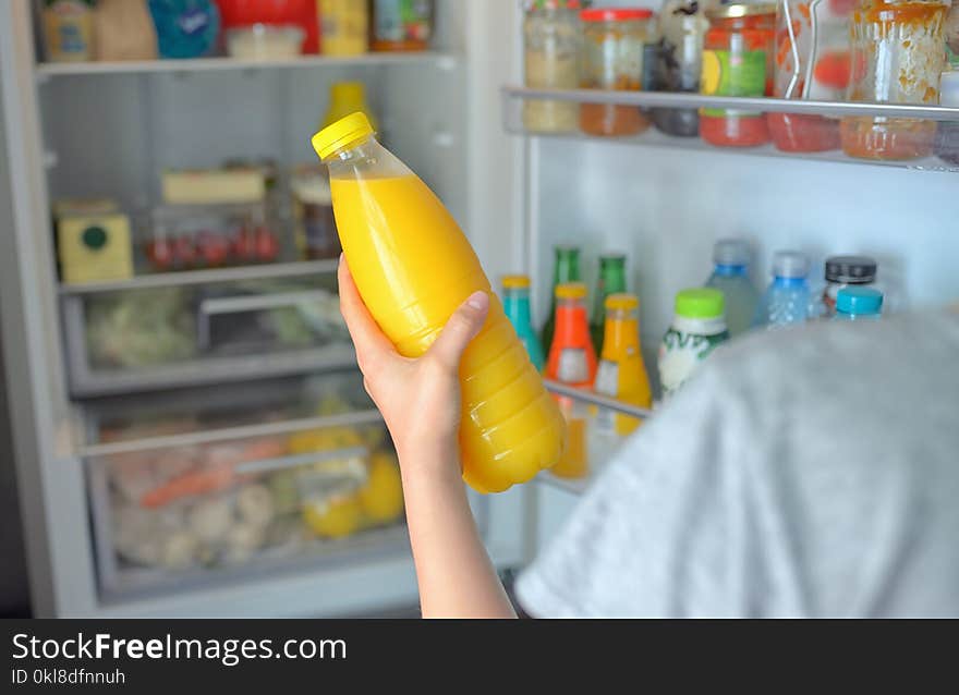 Teenage Girl Takes The Orange Juice From The Refrigerator