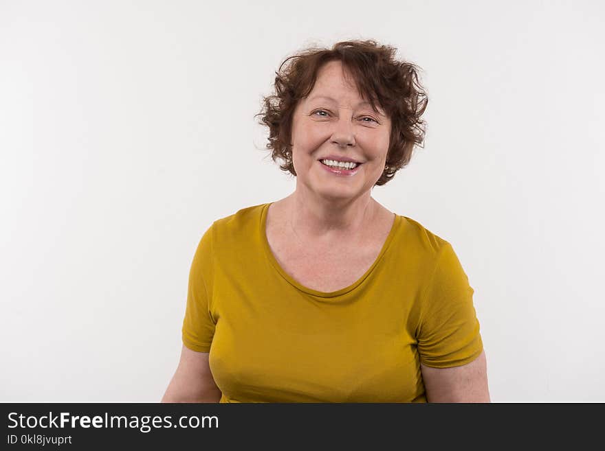 Mature age. Cheerful elderly woman smiling while looking at you