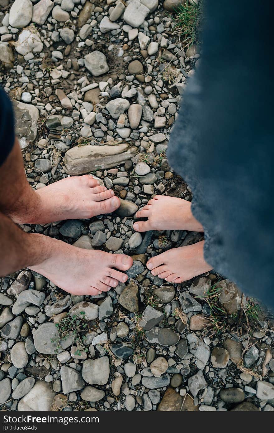 Two pairs of bare feet stand on stones and receive vital energy