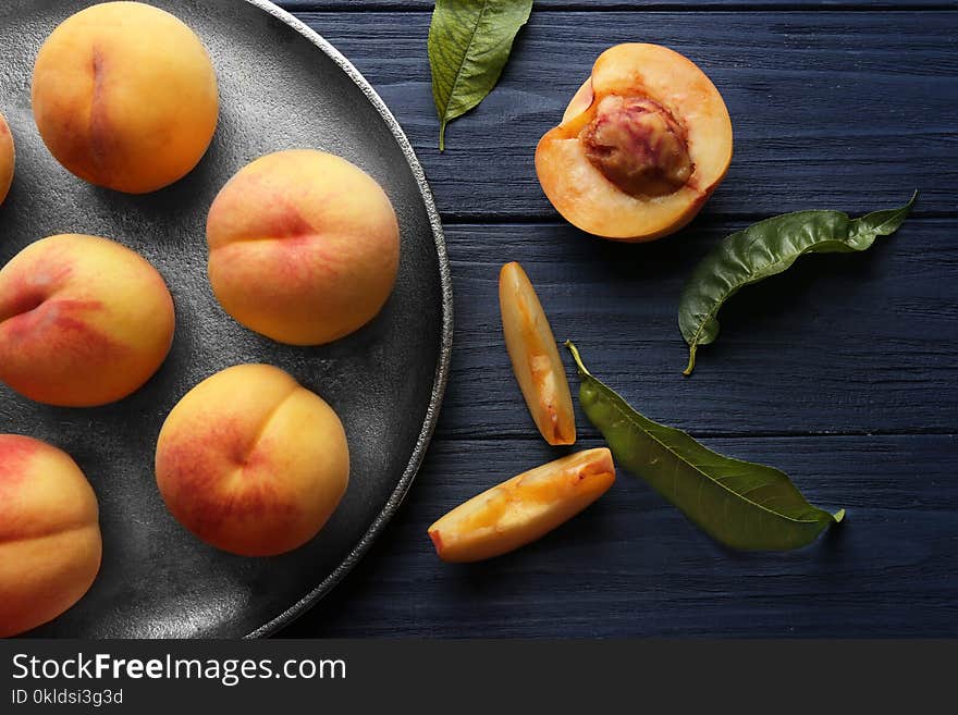 Fresh juicy peaches in tray on blue wooden background