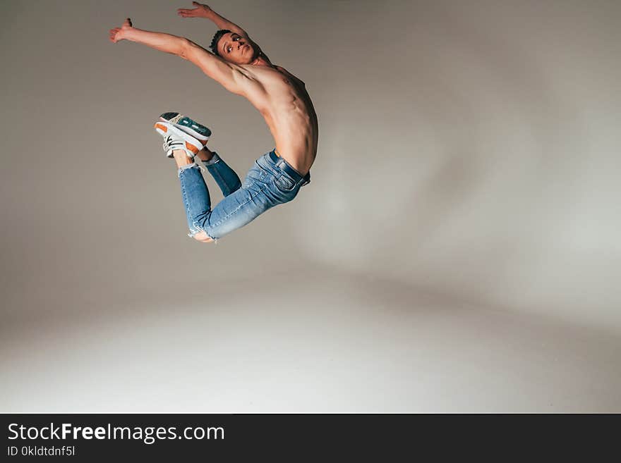 Shot of mad, crazy, cheerful, successful, lucky guy in casual outfit, jeans, jumping with hands up,triumphant, gesturing against w