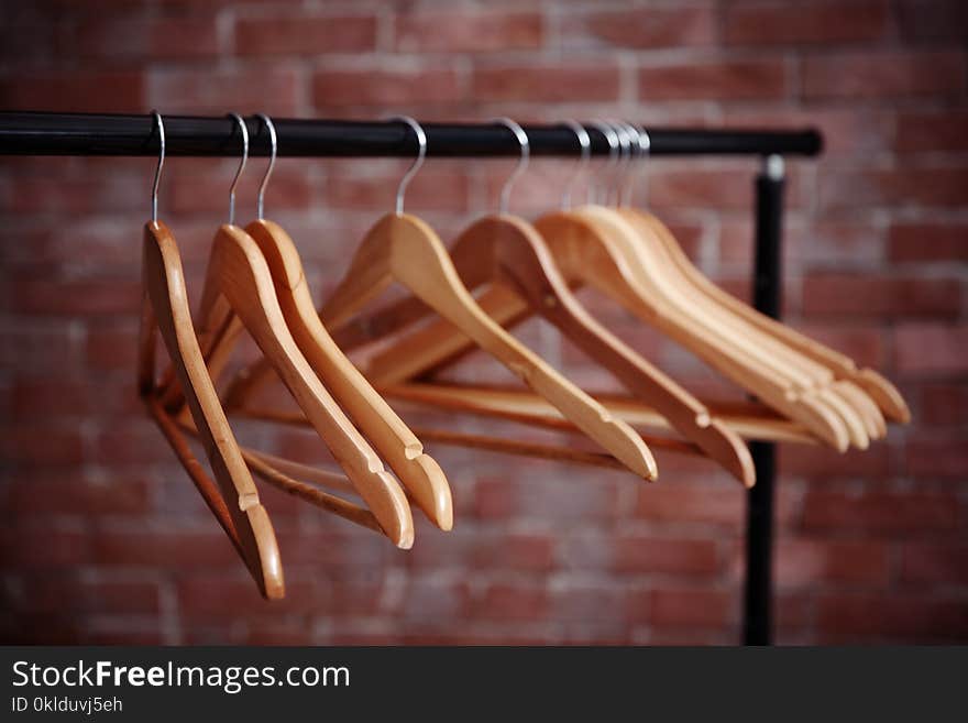 Clothes rail with hangers on blurred brick wall background