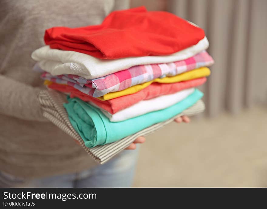 Woman holding pile of clothes, closeup