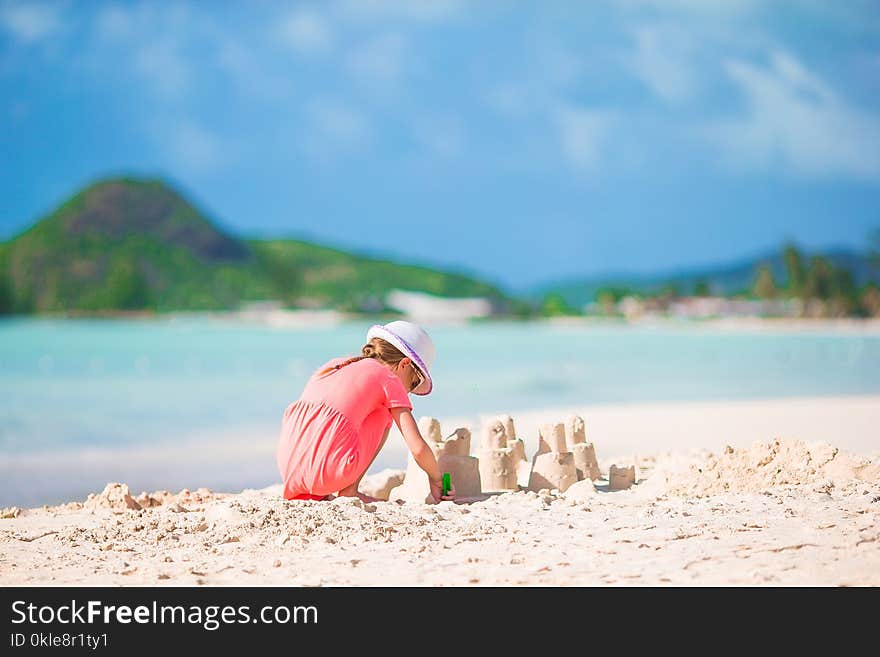 Little girl at tropical beach making sand castle. Little girl at tropical beach making sand castle