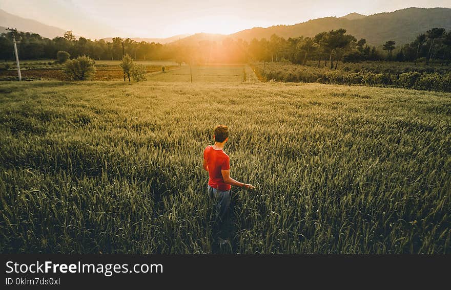 Man Standing in the Middle of the Grass Field