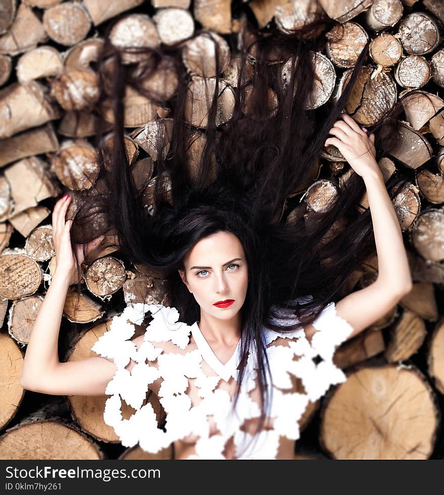 Woman Lying Down on Bunch of Logs