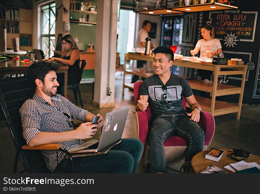 Photograph of Men Having Conversation Seating on Chair