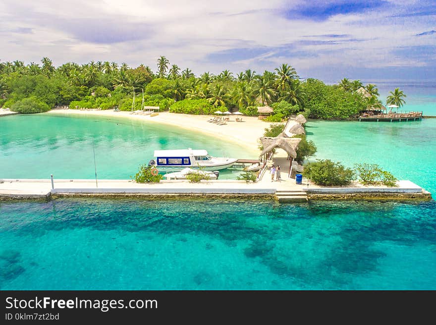 Aerial Photography of White Dock by the Ocean Surrounded With Trees Under Blue Sky and White Clouds