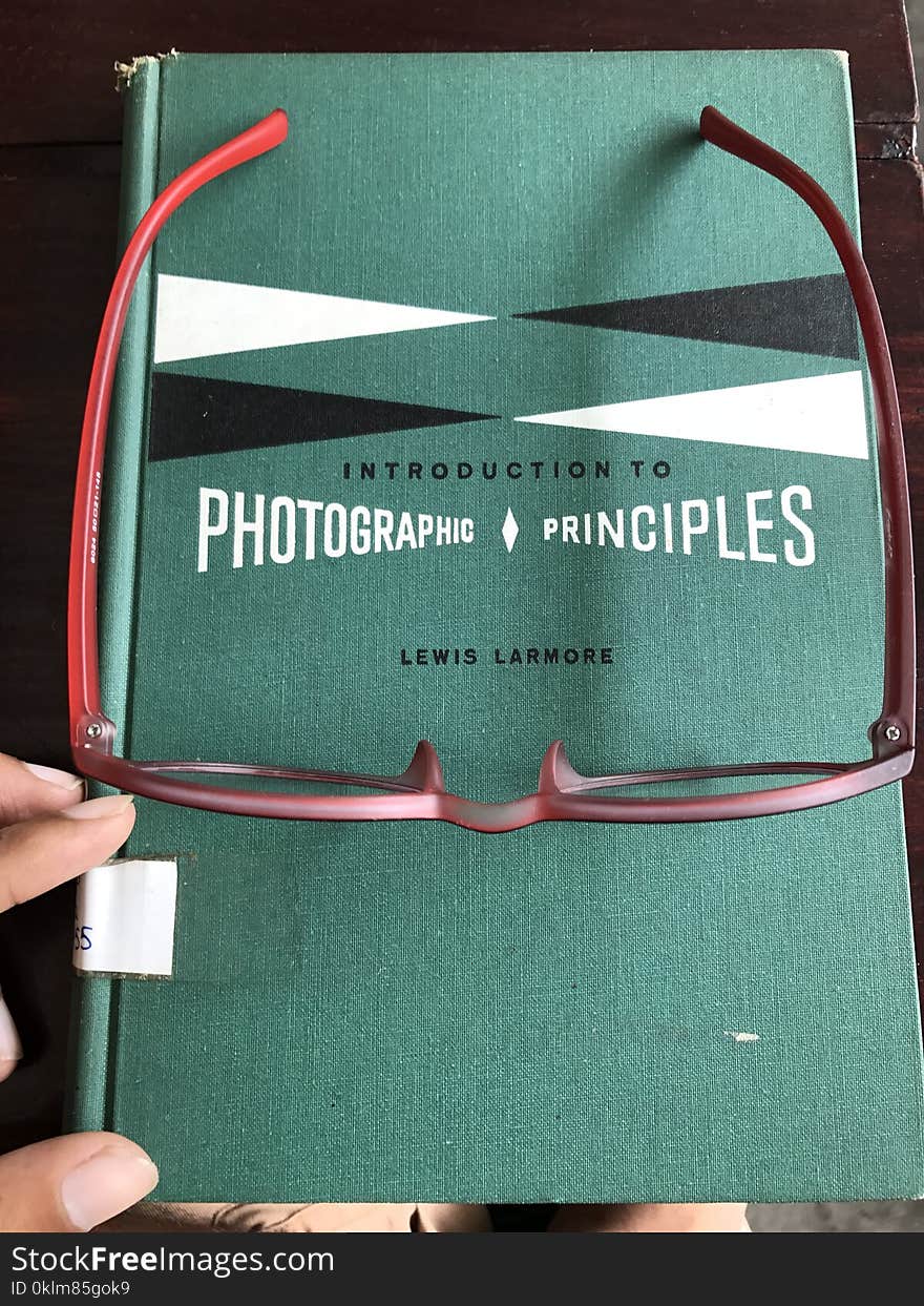 Eyeglasses With Red Frames on Blue Book