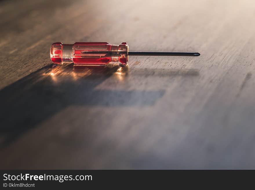 Red Driver on Brown Wooden Surface