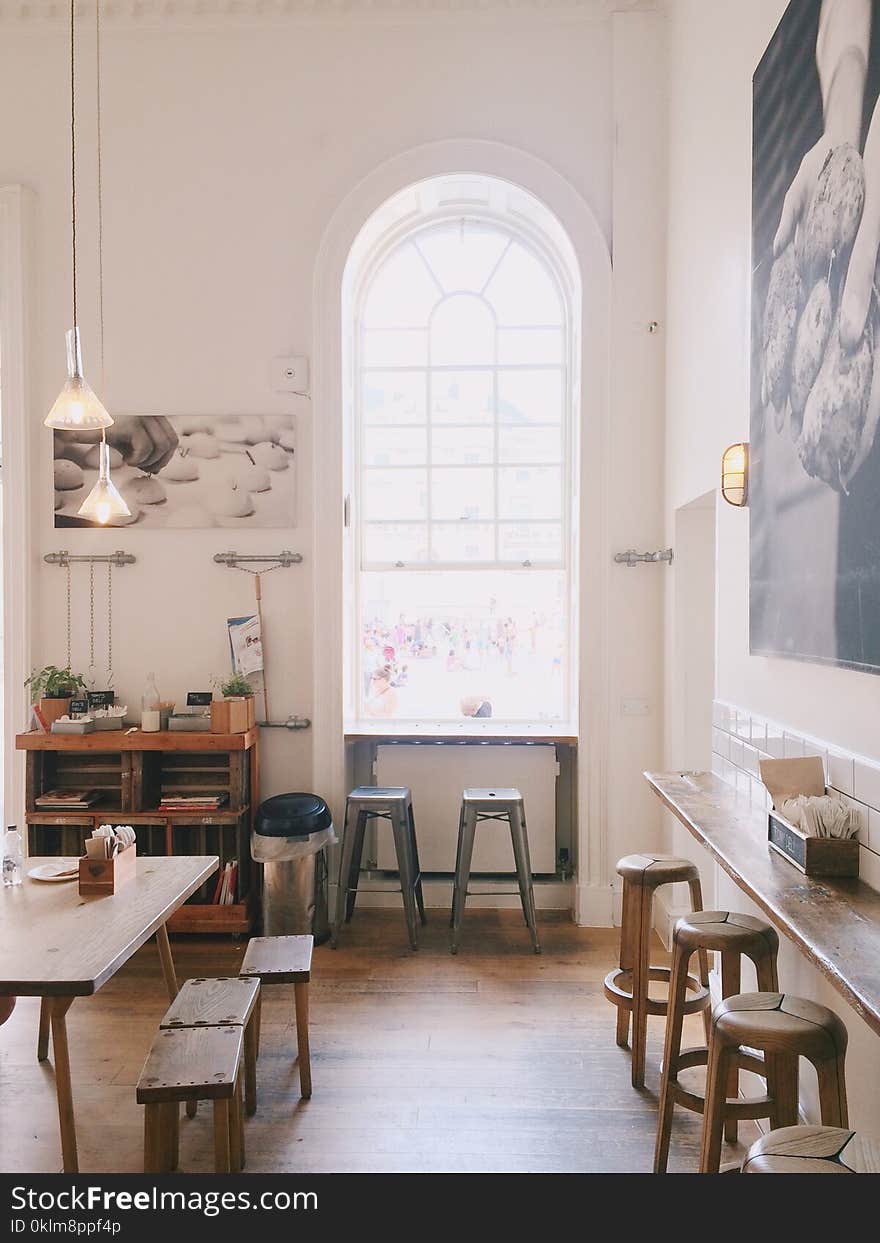 Two Grey Wooden Stools Near Window With Arc Frame