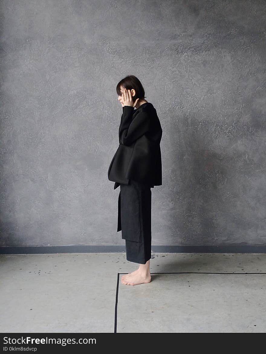 Woman in Black Gi Standing Beside Gray Wall