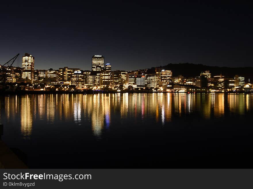 Lighted High-rise Building in Front of Body of Water Photo